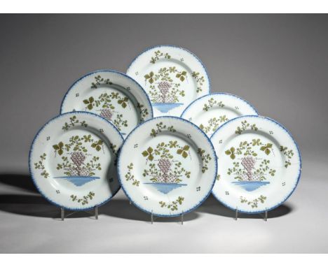 Six Lambeth delftware plates  c.1780-90, painted in green, manganese and blue with a bunch of grapes on the vine suspended ab