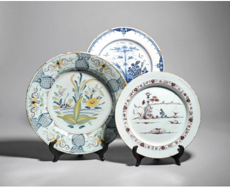 Two delftware chargers  mid 18th century, one painted in manganese with blue detailing, with a figure fishing beside rockwork