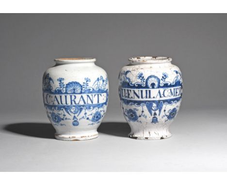 Two delftware dry drug jars  mid 18th century, of ovoid shape, each painted in blue with a narrow cartouche topped by winged 