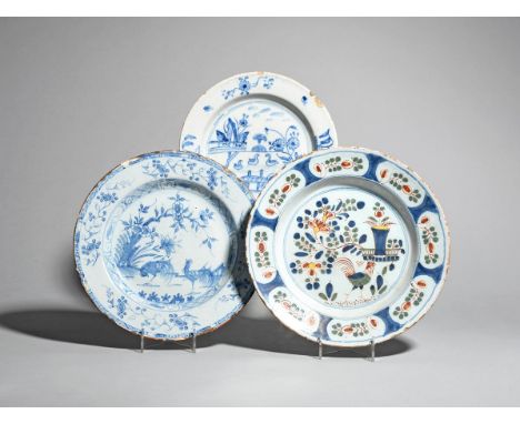 Two large delftware plates  c.1730-40, one Liverpool and painted in blue with two cockerels beneath a bending spray of flower