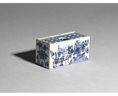 A small delftware flower brick  c.1760, the rectangular form painted in shades of blue with flowering branches issuing from a