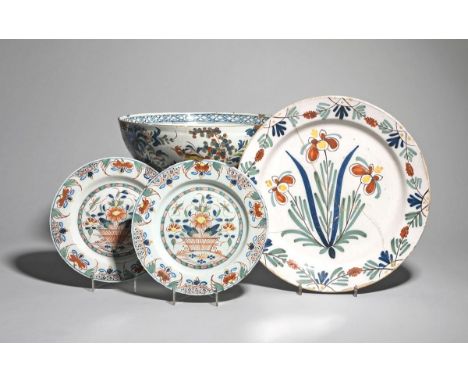 A near pair of Lambeth delftware plates  mid 18th century, painted in bold polychrome enamels, each with a basket of flowers,