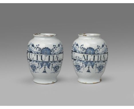 A pair of delftware drug jars  mid 18th century, the ovoid bodies painted in blue with narrow cartouches surmounted by winged