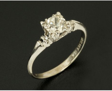 A white gold coloured metal solitaire diamond ring, stamped "10 k", size L/M.