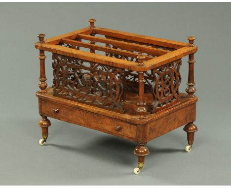 A Victorian walnut Canterbury, with three apertures, fretwork sides, single drawer and raised on turned legs terminating in c