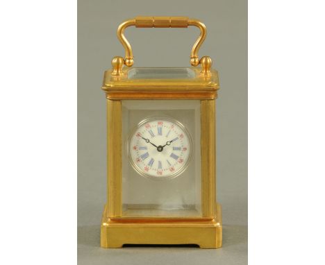 A miniature brass carriage clock timepiece, with enamelled circular dial with Roman and Arabic numerals.  Height 7.8 cm inclu