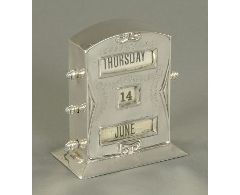 A perpetual desk calendar, early 20th century, with day, date and month apertures, framed by engraved foliate swags and havin