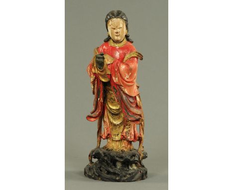 A Chinese carved wood figure of a lady, 19th century, dressed in red and gilt robes and holding a covered pot, her black hair