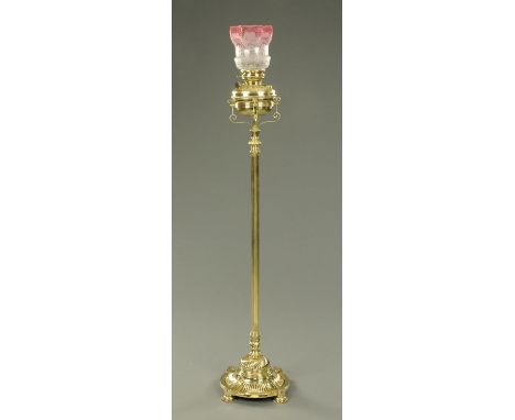 A Victorian brass standard lamp, with circular base raised on four short circular feet.