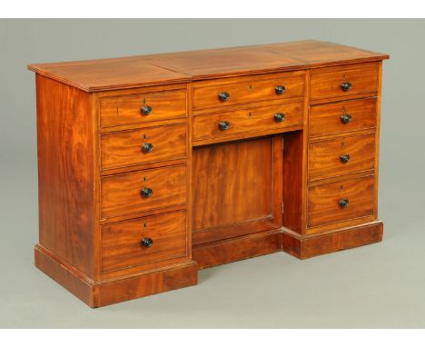 An early 19th century mahogany desk, the top with two hinged flaps and the front modelled as a series of drawers, dummy drawe