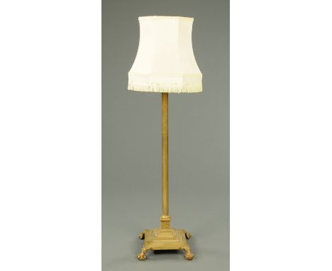 A Victorian brass lamp standard, with Corinthian capital and square stepped base raised on paw feet.  