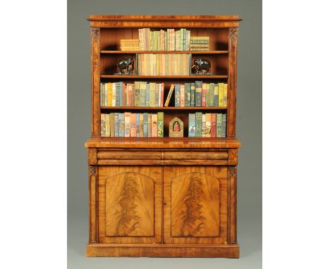 A Victorian mahogany bookcase, with caddy top above a series of open shelves, the base fitted with two drawers above a pair o