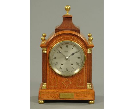 An Edwardian brass inlaid oak mantle clock, inscribed "Rowell, Oxford", with two-train striking movement.  Height 45 cm, widt