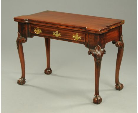 A George III mahogany card table, with inverted breakfront opening to a baize lined interior with counterwells and fitted wit