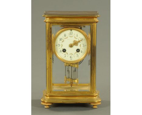An Edwardian brass four glass mantle clock, with mercury weighted pendulum, serpentine base and two-train striking movement. 