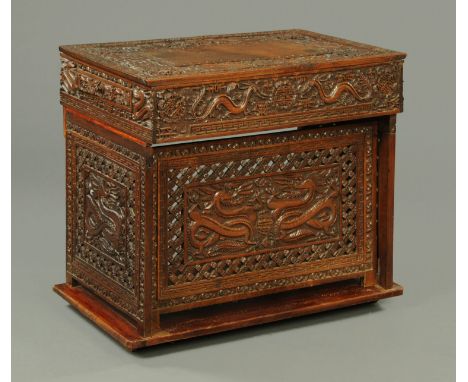 A Chinese carved hardwood collapsible desk, 19th century, profusely carved throughout with dragons, Shou, bats, peony and wan