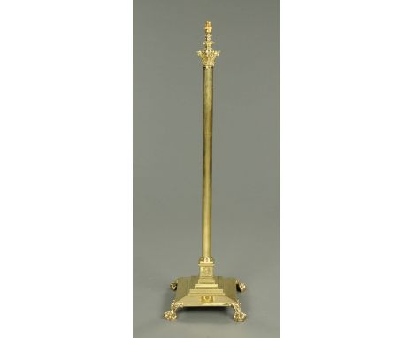 A Victorian brass lamp standard, adjustable, converted to electricity and raised on a stepped base with claw and ball feet.  