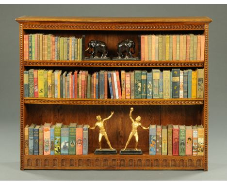 An Edwardian oak open bookcase, with moulded edge above a carved frieze and fitted with shelves.  Width 135 cm, height 108 cm