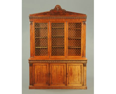 A William IV mahogany bookcase, with architectural pediment above three doors each with brass grille (two glazed), the base f