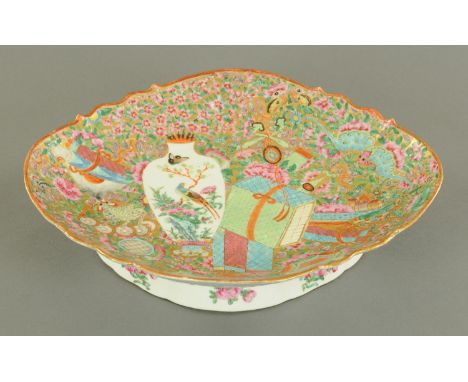 A good Canton enamel oval pedestal dish, mid 19th century, typically decorated with auspicious objects to include books, scro