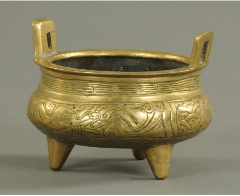 A Chinese polished bronze censer, late 19th/20th century, with pierced lug handles and key border above a dragon amongst scal