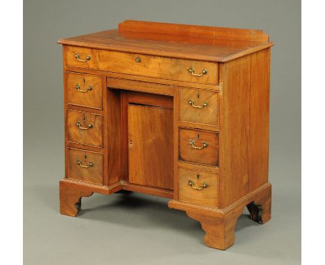 A 19th century mahogany kneehole desk, with rear upstand, frieze drawer, recessed cupboard and three further drawers to each 