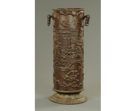 An embossed brass cylindrical stick stand, chinoiserie style with faux bronze finish, height 56 cm.