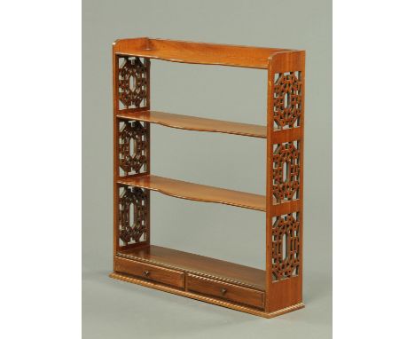 An Edwardian mahogany open wall hanging shelf unit, with fretwork sides and fitted with two short drawers.  Width 70.5 cm, he