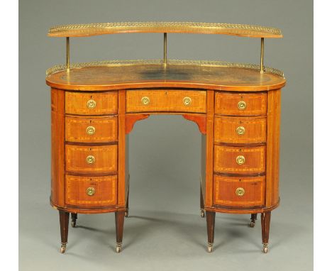 An Edwardian inlaid mahogany kidney shaped desk, with rear shelved stand, fitted to the frieze with a drawer and with four fu