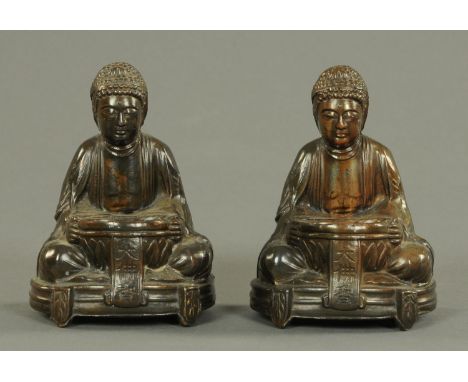 A pair of Japanese hollow cast Buddhas, early 20th century, each in meditative pose, with an offering bowl resting on lotus l