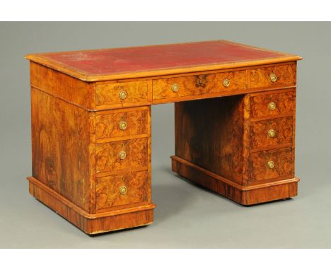 A Victorian burr walnut pedestal desk, with red tooled leather writing surface, fitted with three frieze drawers, and three f