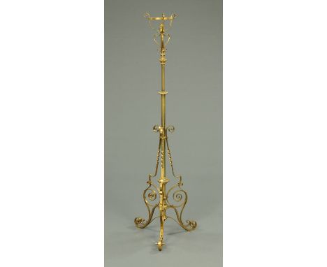 A Victorian brass lamp standard, with adjustable mechanism and three scroll supports.     CONDITION REPORT:  The lamp is full