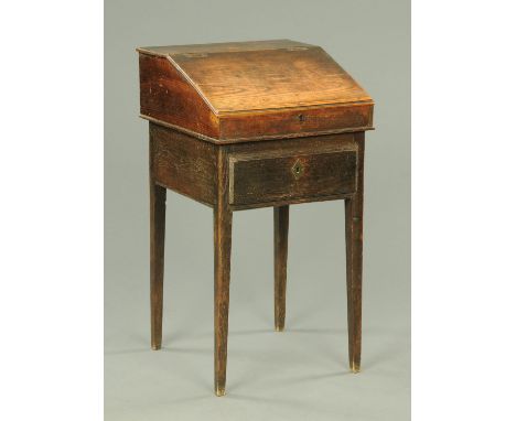 An antique oak child's or clerks desk, raised on a stand, fitted with a drawer and with tapered legs of square section.  Widt