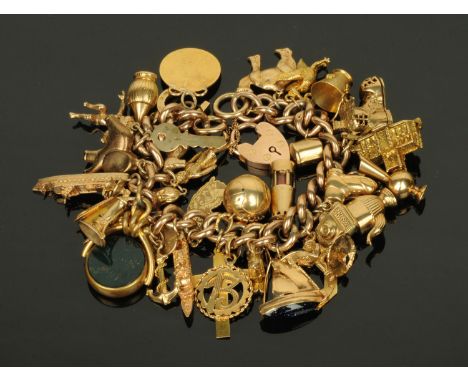 A 9 ct gold charm bracelet, with padlock and safety chain, 104 grams (see illustration).   CONDITION REPORT:  There are 33 ch