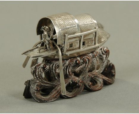 A Chinese miniature silver junk, late 19th century, having double canopy with a single figure at the back, with two oars and 