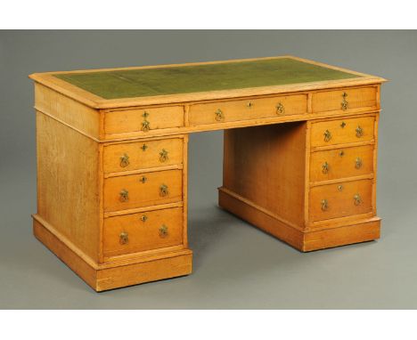 A late Victorian oak twin pedestal desk, with green tooled leather writing surface, three frieze drawers and three further dr