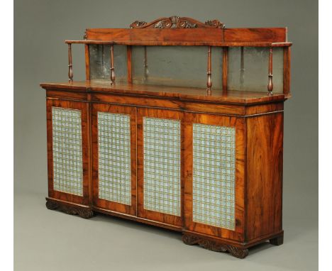A William IV Goncalo Alves breakfront side cabinet, with scroll carved rear pediment above a shelf, turned columns and mirror