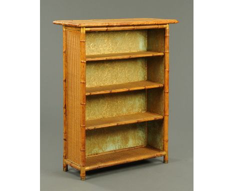 A late 19th/early 20th century rattan shelf unit, the brass feet stamped "Neadham".  Width 94 cm, depth 38 cm, height 117 cm.