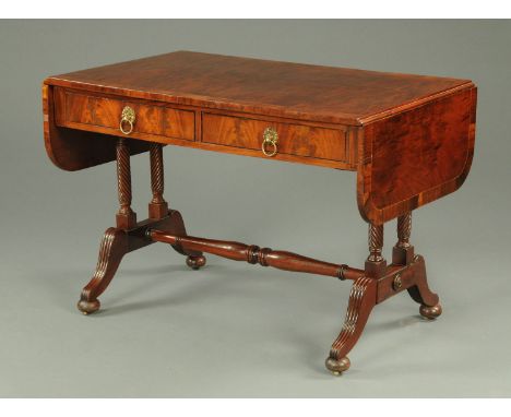 A mahogany and rosewood banded sofa table, in the Regency style, fitted with two drawers and raised on turned supports with c