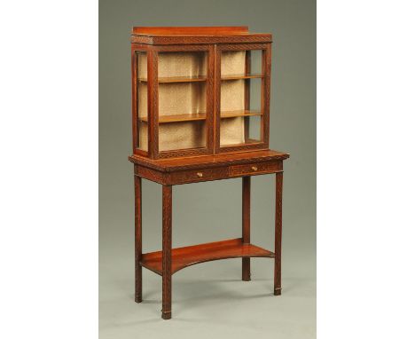 An Edwardian Chippendale style glazed cabinet on stand, blind fretwork carved, the base fitted with two drawers and a low she