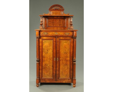 A Victorian mahogany and walnut cupboard, with rear arched pediment and shelf and with single drawer above a pair of panelled