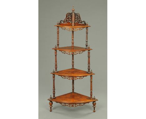A Victorian walnut four tier corner whatnot stand, with fretwork pediment and turned columns raised on short feet.     CONDIT