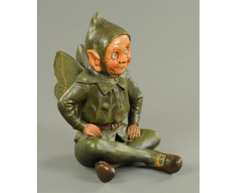 A continental painted terracotta pixie, late 19th/early 20th century, wearing a pointed hat framing his mischievous looking f