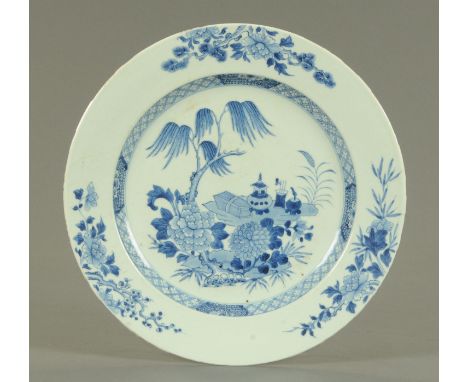 A Chinese blue and white dish, mid 18th century, decorated with incense burner and tools, beneath a willow tree with peony, a