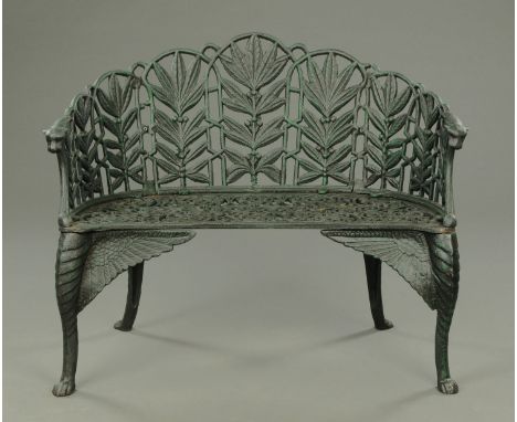 A Victorian style cast iron garden bench, bowed form, with foliate back, pierced seat and cabriole legs terminating in paw fe