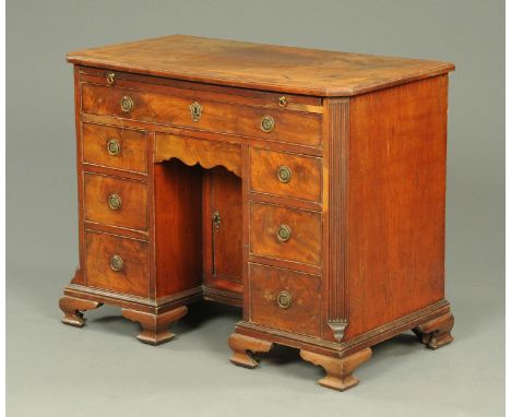 A George III mahogany kneehole desk, fitted with a slide, frieze drawer, three further shallow drawers and recessed cupboard,
