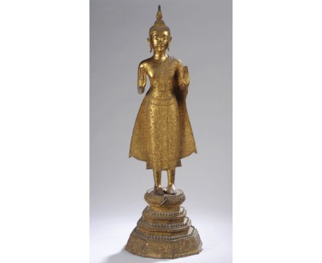 Buddha debout sur un haut tertre octogonal étagé serti de frises dentelées surmonté d'un e base lotiforme oblongue en Abaya M