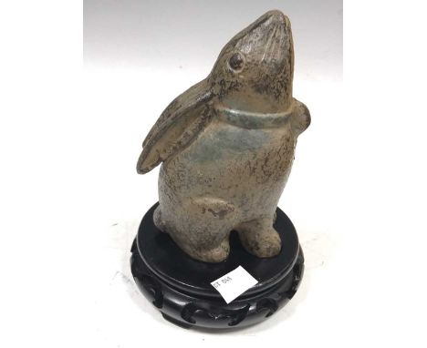Chinese cast iron model of a moon-gazing pet hare (or rabbit) wearing a neck bell 15.5 cms. On wood stand.Similar Chinese cas