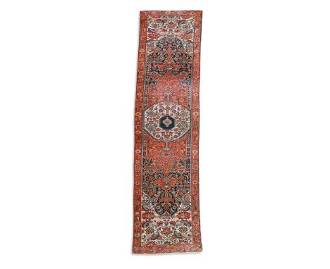 A Persian runner, possibly Heriz/Karaja, early 20th century, the central ivory medallion on a red ground, with ivory spandrel
