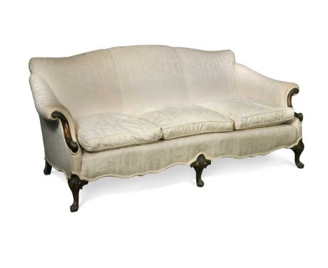 A Georgian III style mahogany three seat sofa, with camel back and foliate carved arms and feet, in cream upholstery89 x 200 